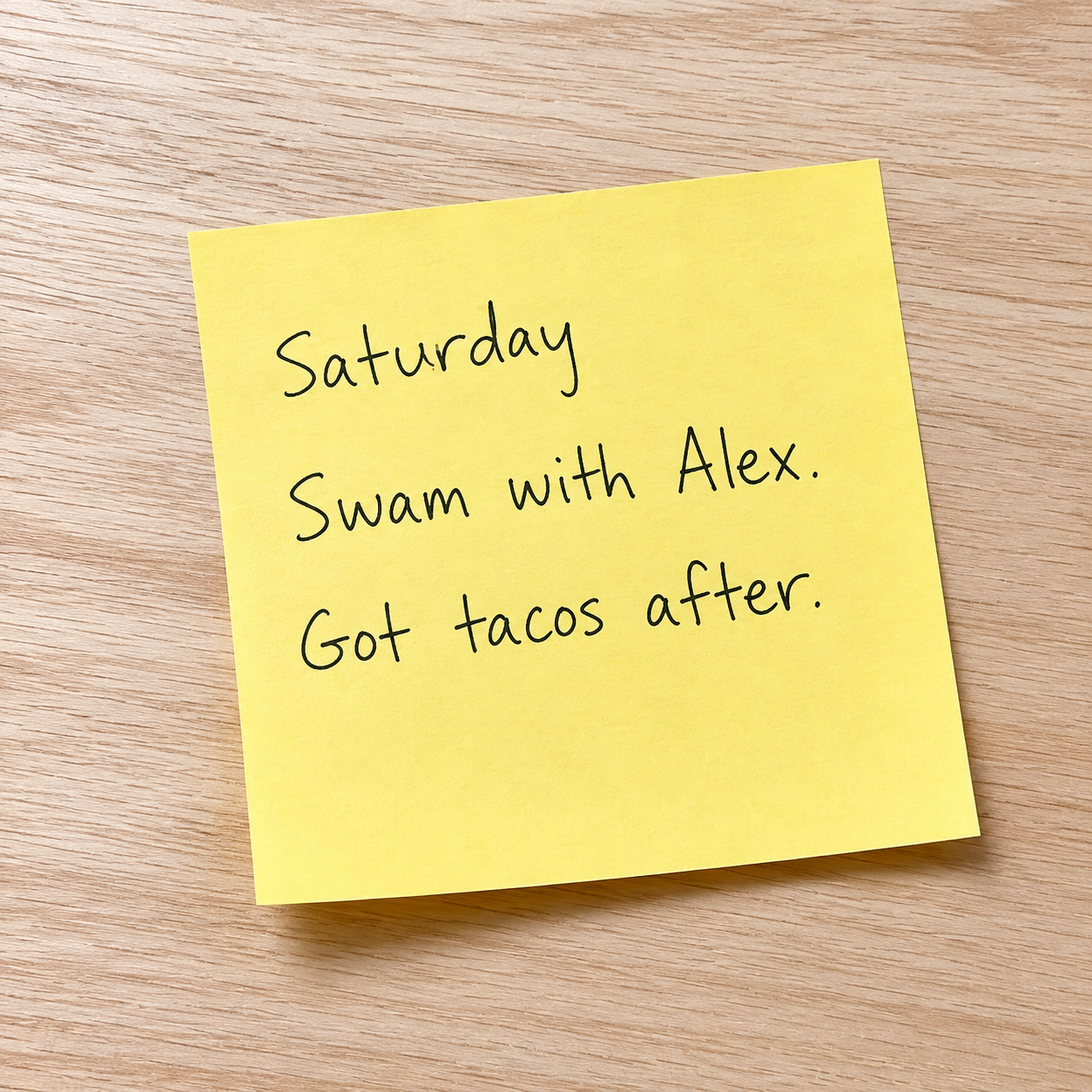 A yellow Post-it on a wood table: Saturday. Swam with Alex. Got tacos after.